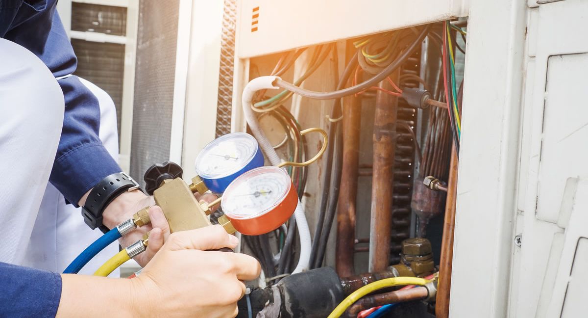 HVAC technician checks AC refrigerant levels
